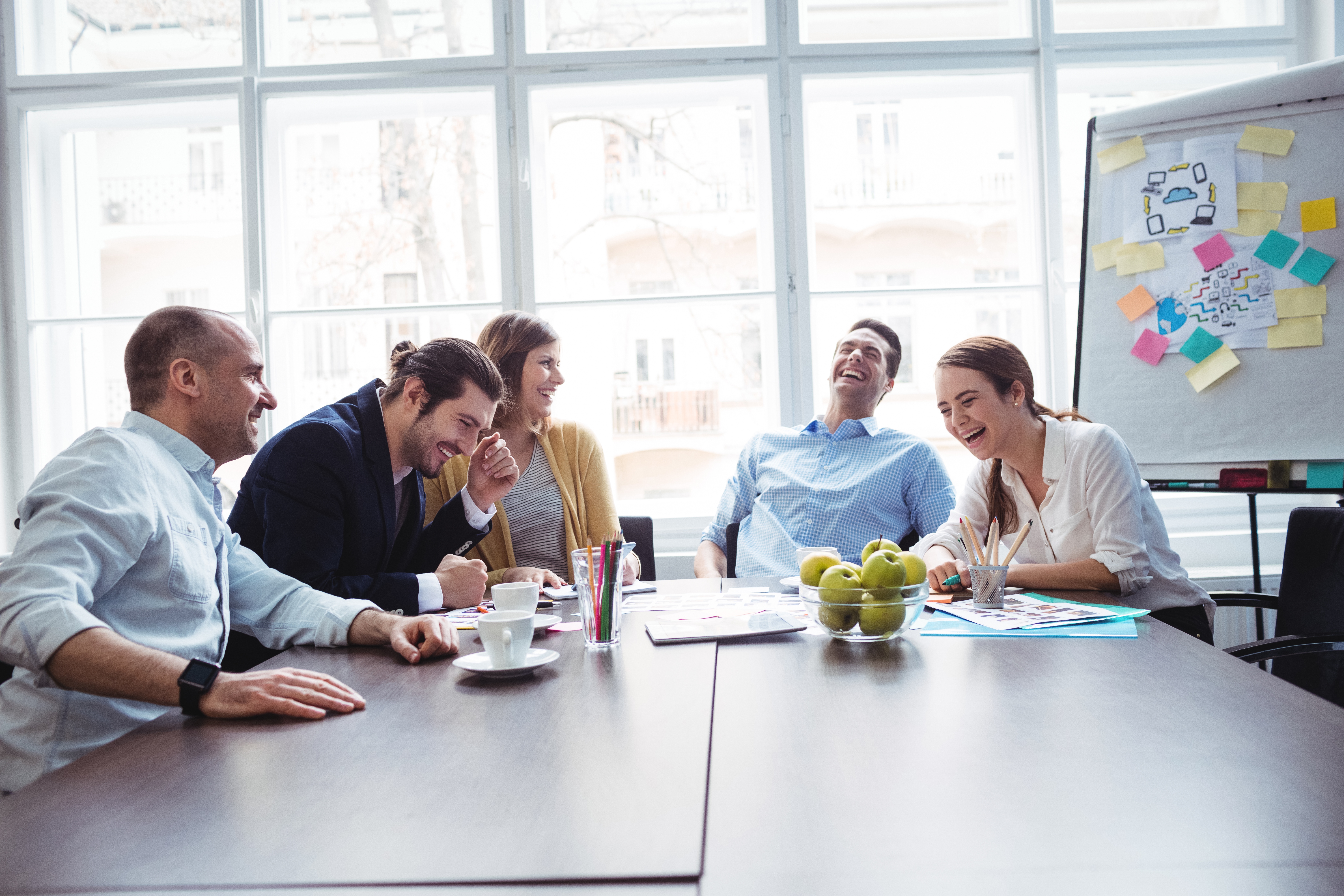 Cheerful colleagues discussing in meeting room